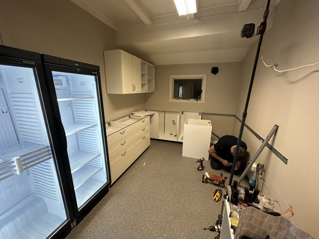 Kristian klargjør vegg før montering av kjøkkenskap