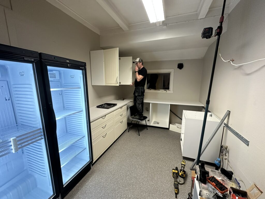 Terje skrur opp kjøkkenskap